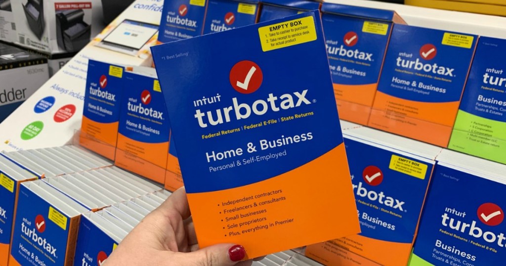 TurboTax Home and Business in hand near in-store display