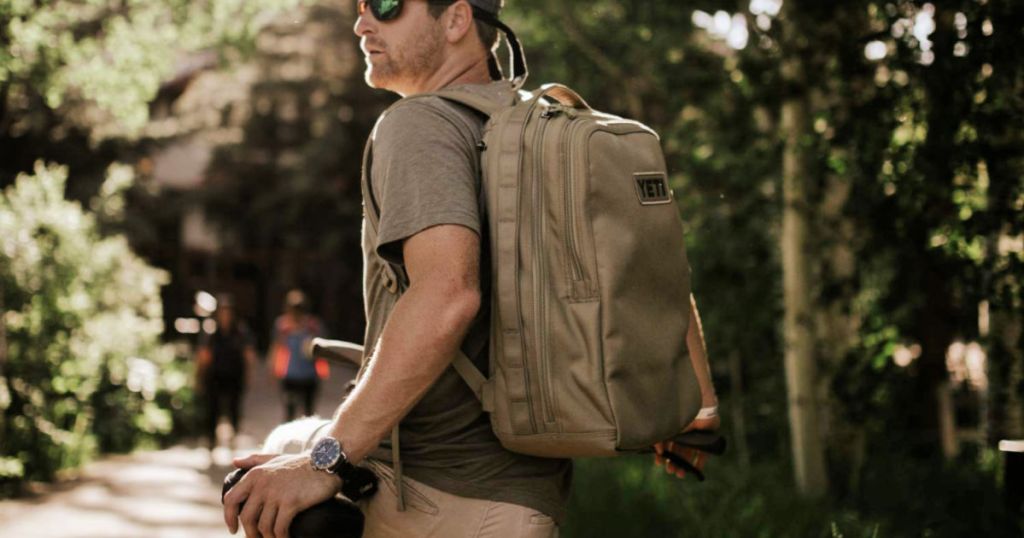 man wearing tan YETI Tocayo 26 Backpack in Black on bike