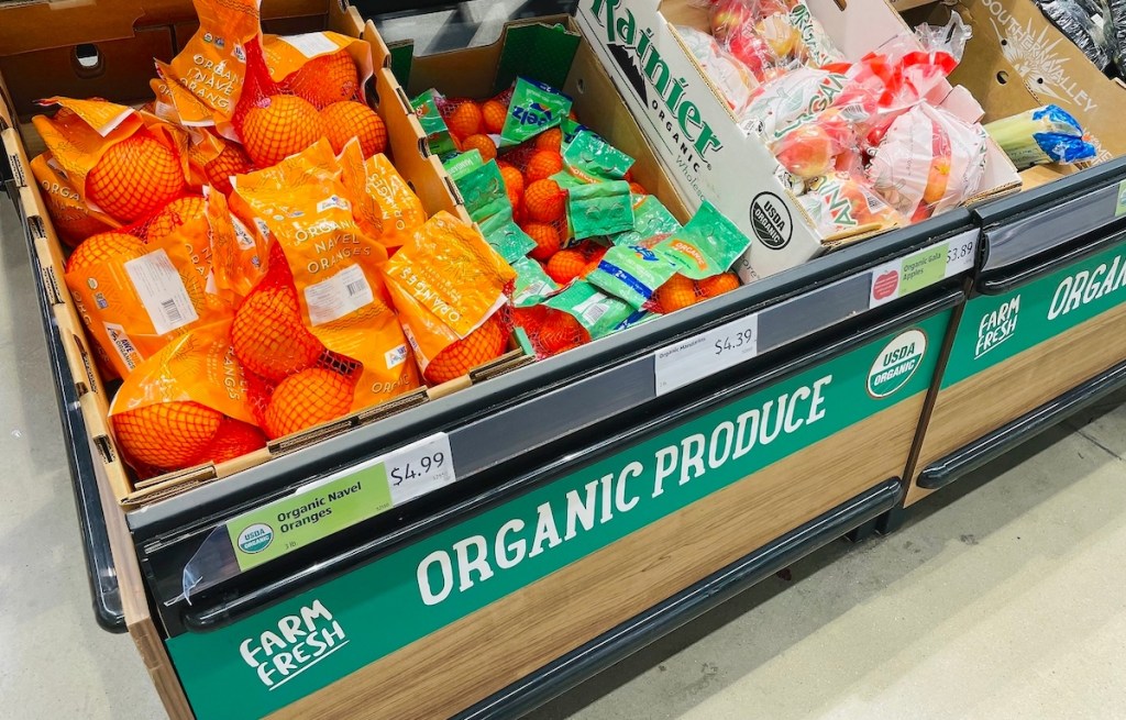 organic produce shelf in store with oranges and apples