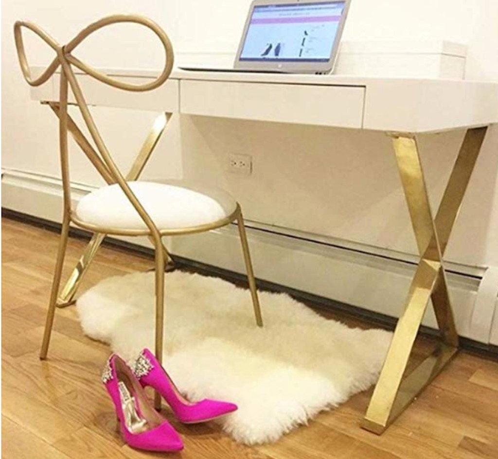 gold bow shaped chair and office desk with onlineputer and hot pink high heels