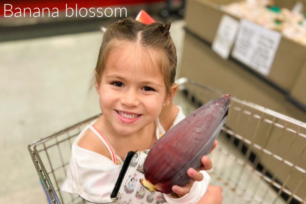 girl holding banana blossom