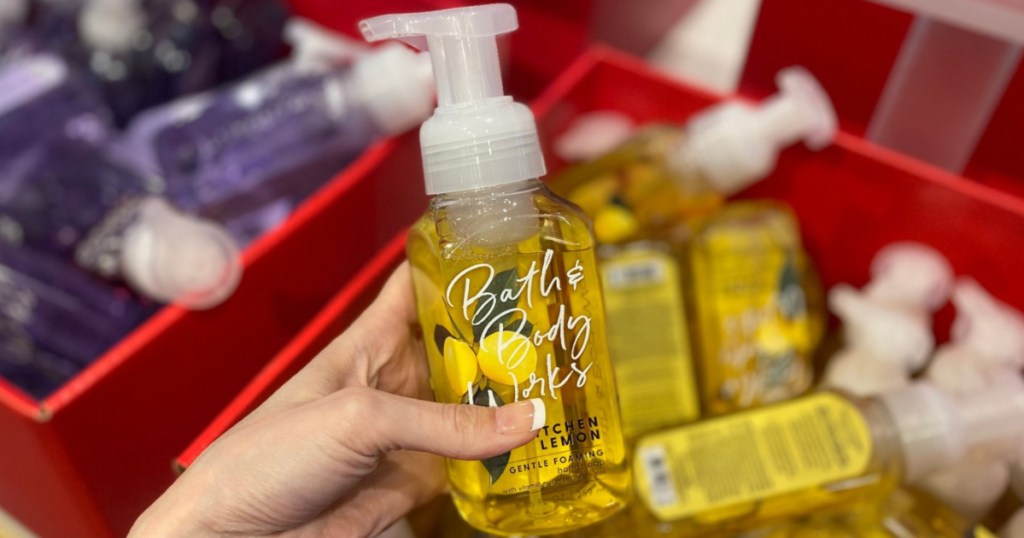 Woman's hand holding lemon hand soap at bath & body works 