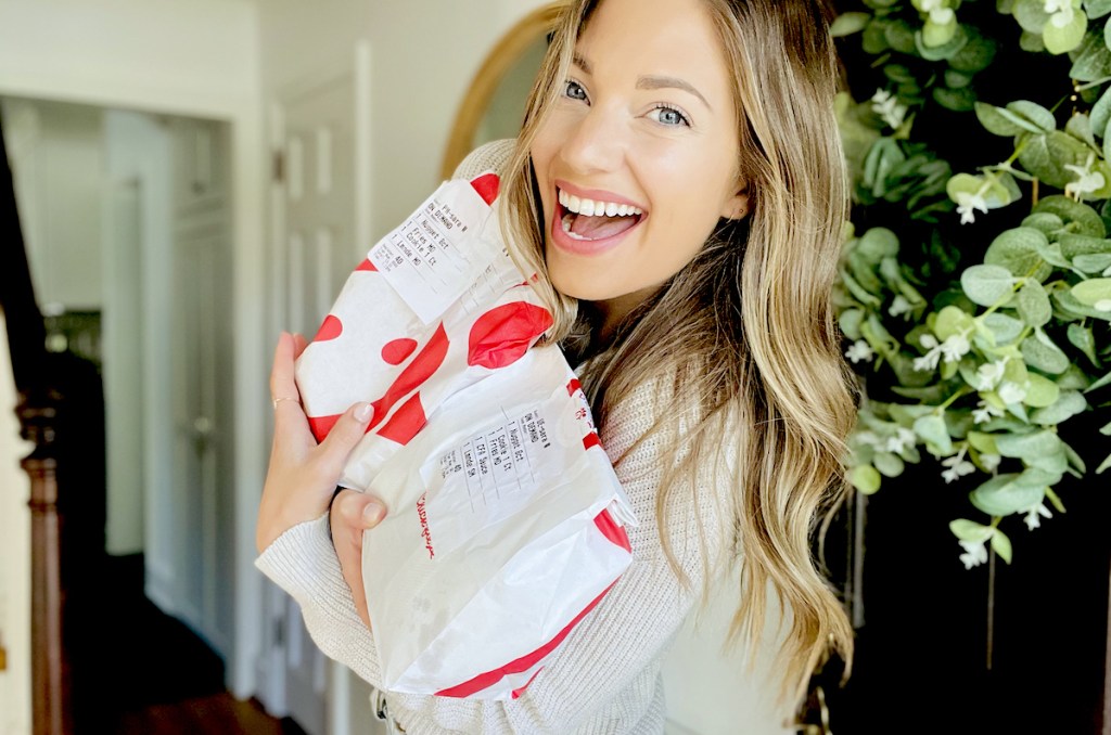 woman standing in doorway holding chick fil a takeout food