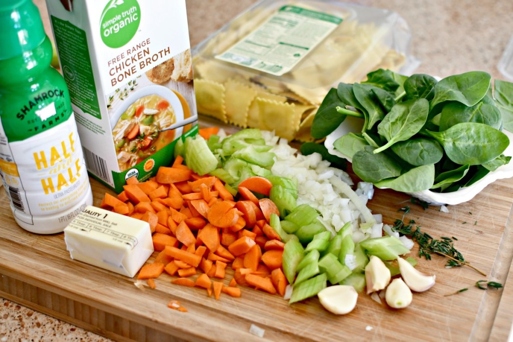 creamy ravioli soup ingredients on a cutting board