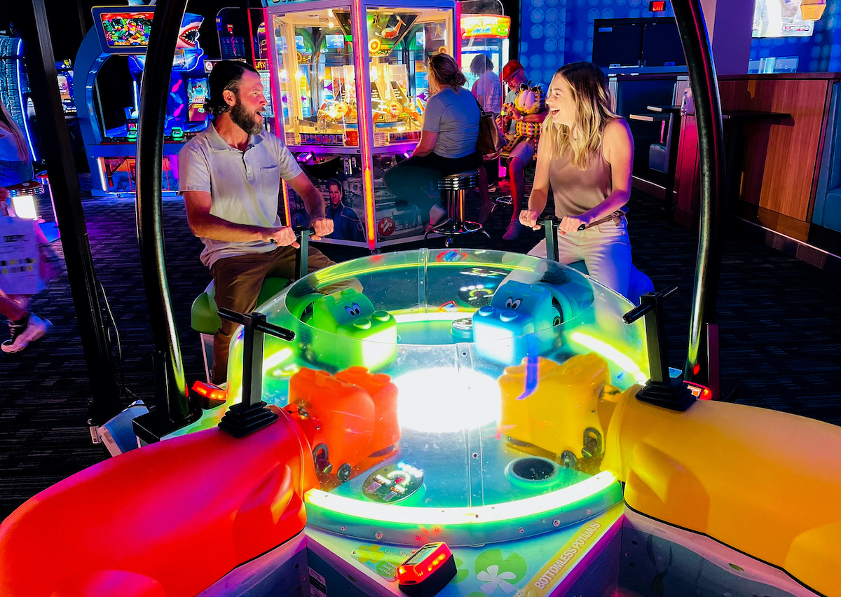 couple sitting on hungry hungry hippo game at dave and busters