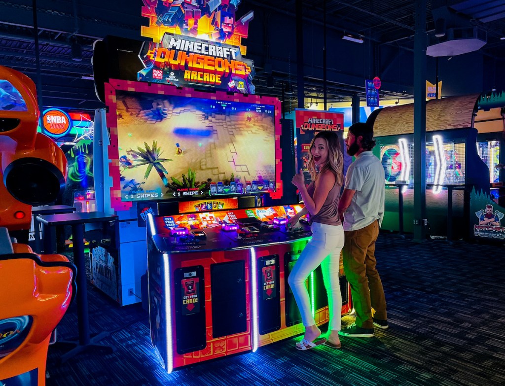 couple standing at minecraft video game at dave and busters