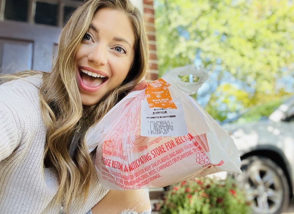 woman holding bag with takeout food