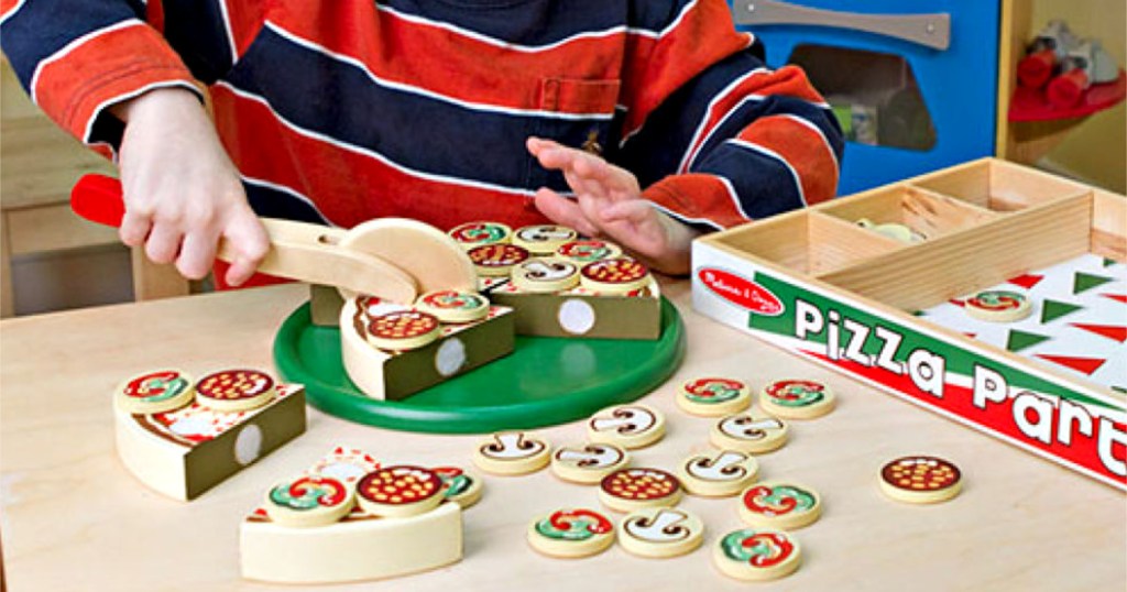 boy playing with melissa and doug wooden playset