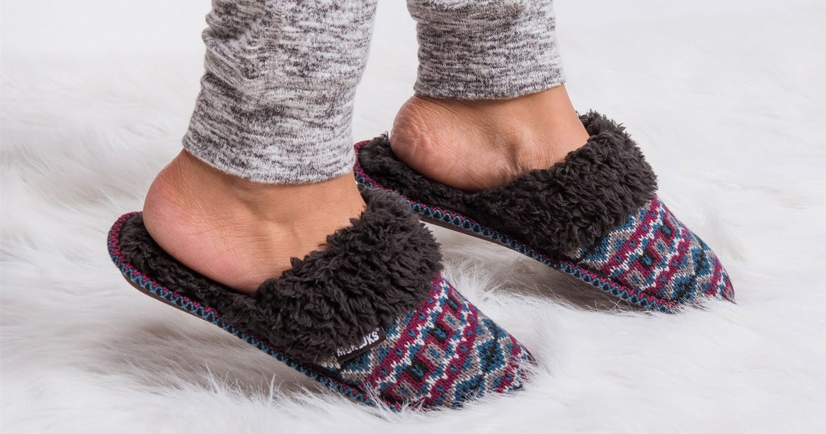 Muk Luks slippers on a fur rug