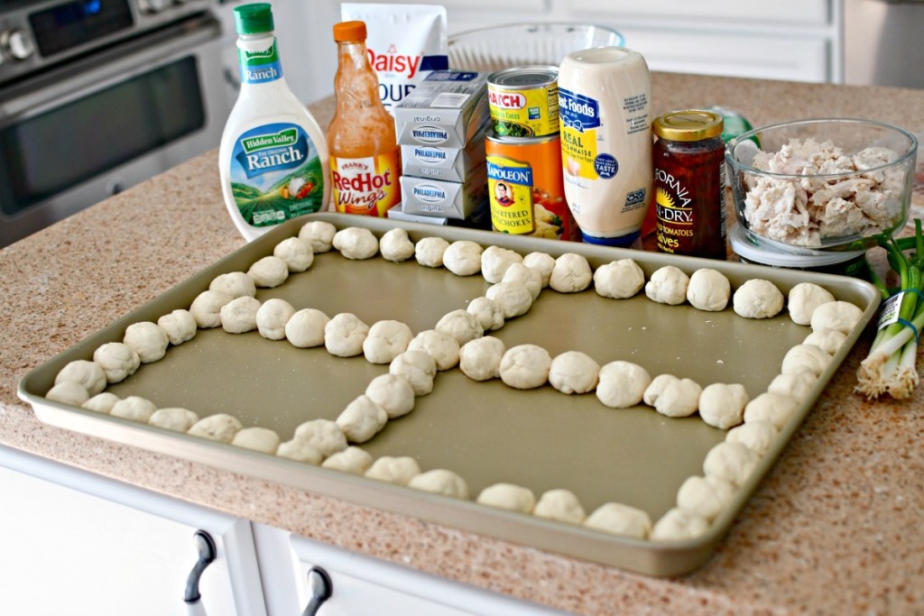 sheet pan with pizza dough balls and 4 dips