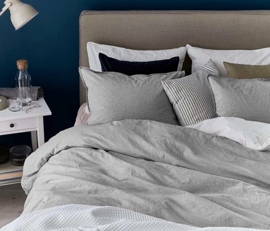 bedroom with pillows and gray and white stripe duvet on bed