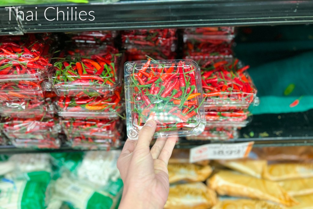 hand grabbing pack of thai chilies