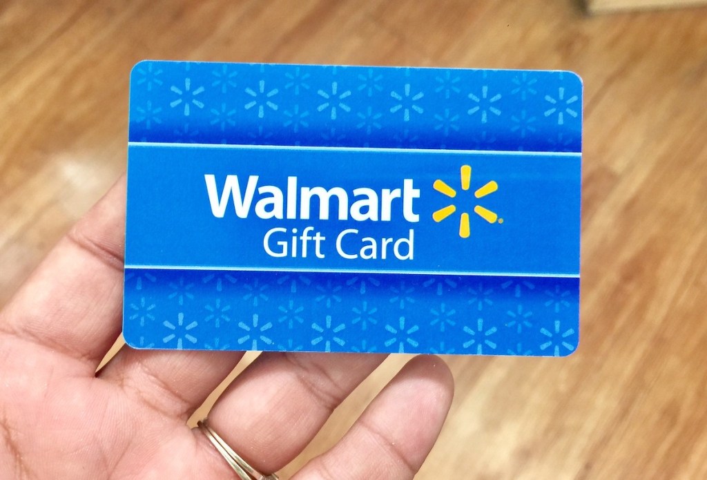 hand holding a blue walmart gift card