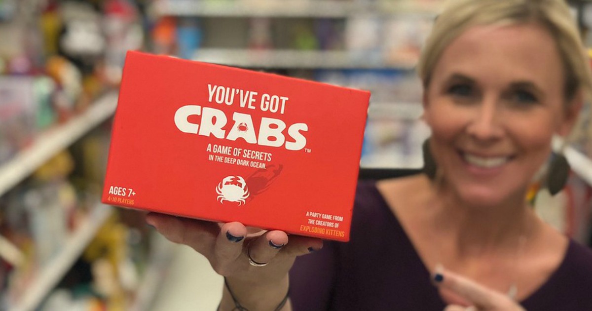 woman holding red card game in toy aisle