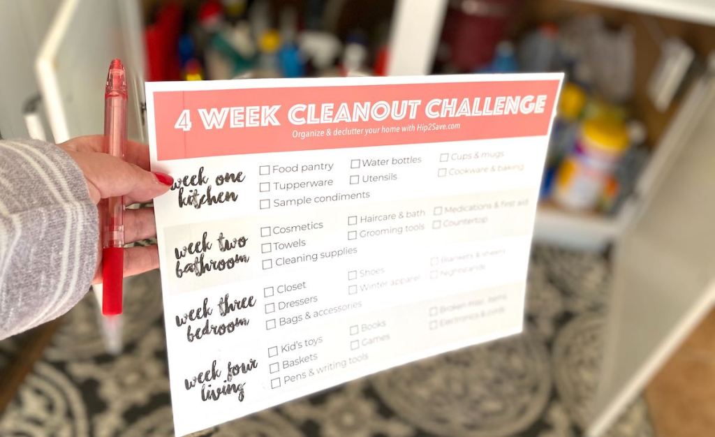 hand holding paper with 4 week cleanout challenge checklist