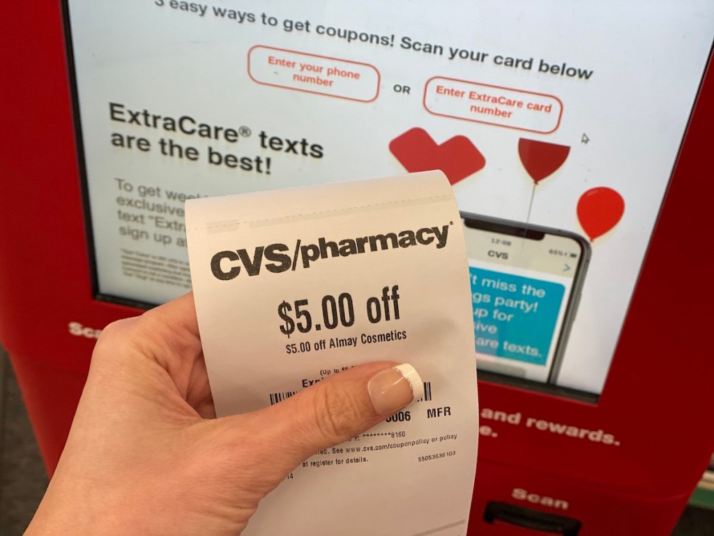 Hand holding Almay Coupon at CVS