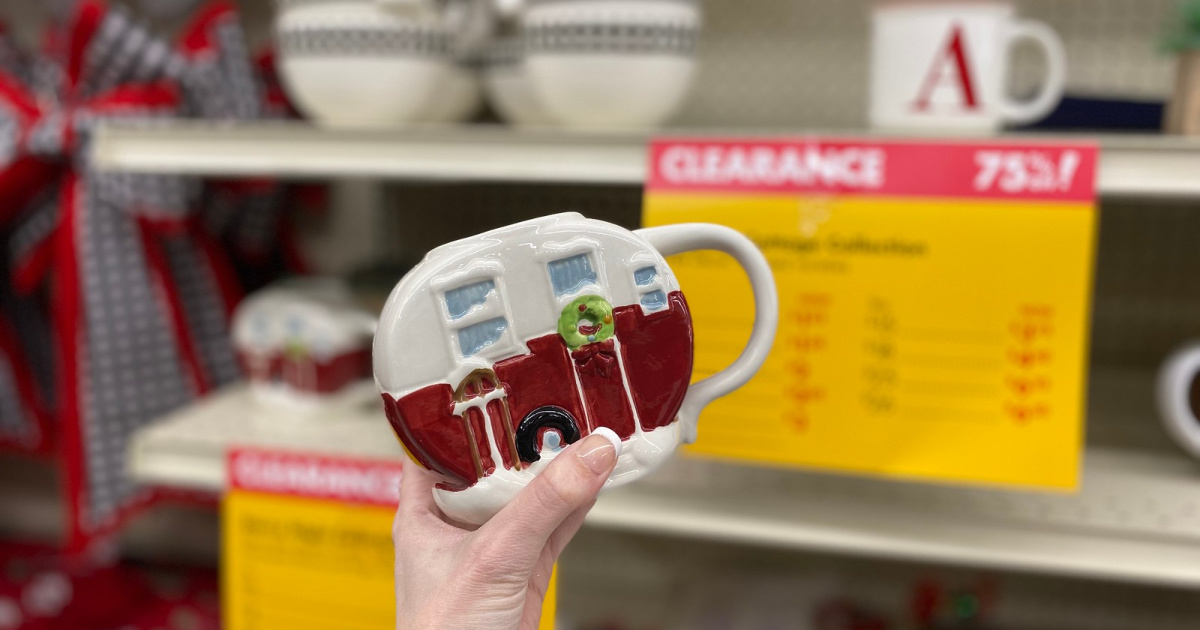 hand holding camper mug with blurry background