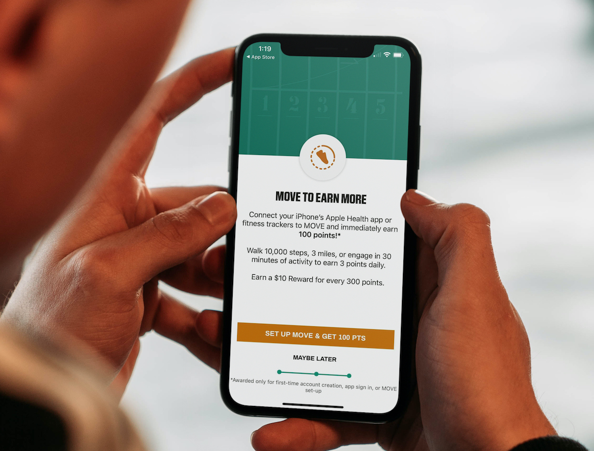 apps that pay you to work out hands holding iphone with dick's sporting goods move workout accountability app on screen