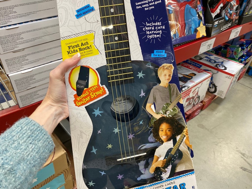 woman holding First Act Acoustic Guitar in box