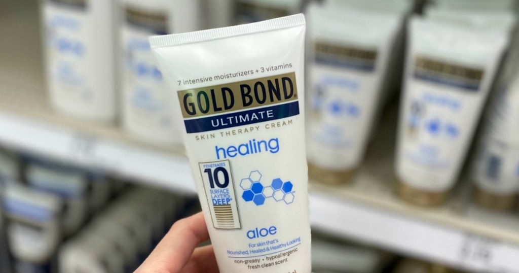 hand holding bottle of Gold Bond Ultimate Hand Cream