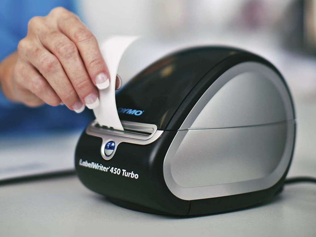 Hand grabbing a printed label from a label printing machine