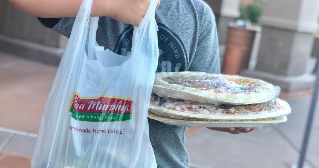 boy holding a Papa Murphy's bag and pizzas