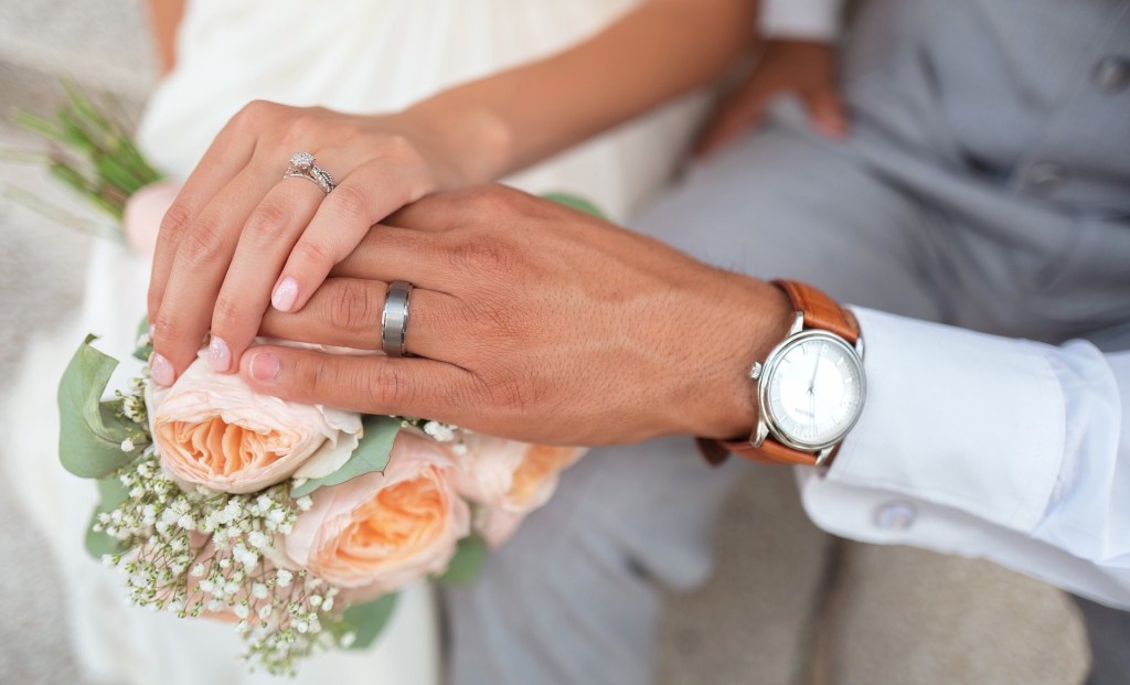 bride and groom hands with flowers