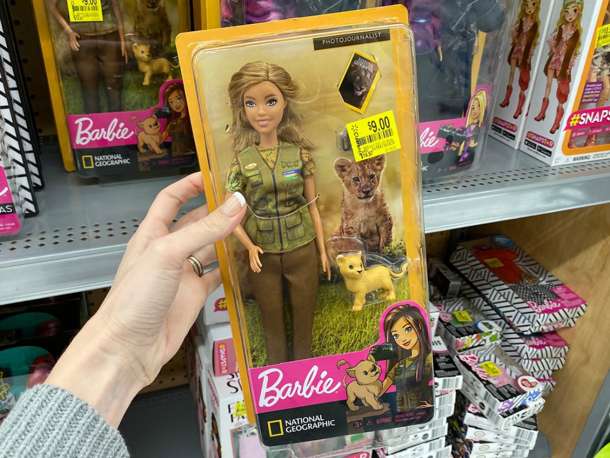 hand holding barbie doll in package at store