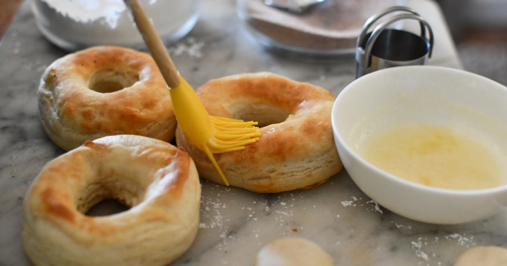 brushing butter on to biscuit donuts