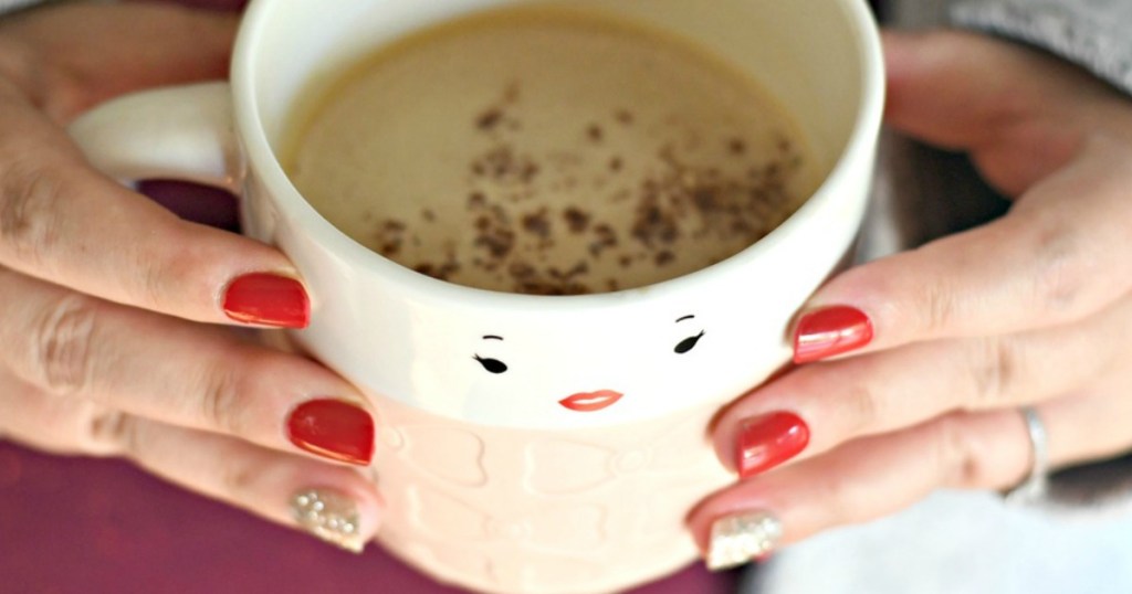 women holding coffee cup with painted nails