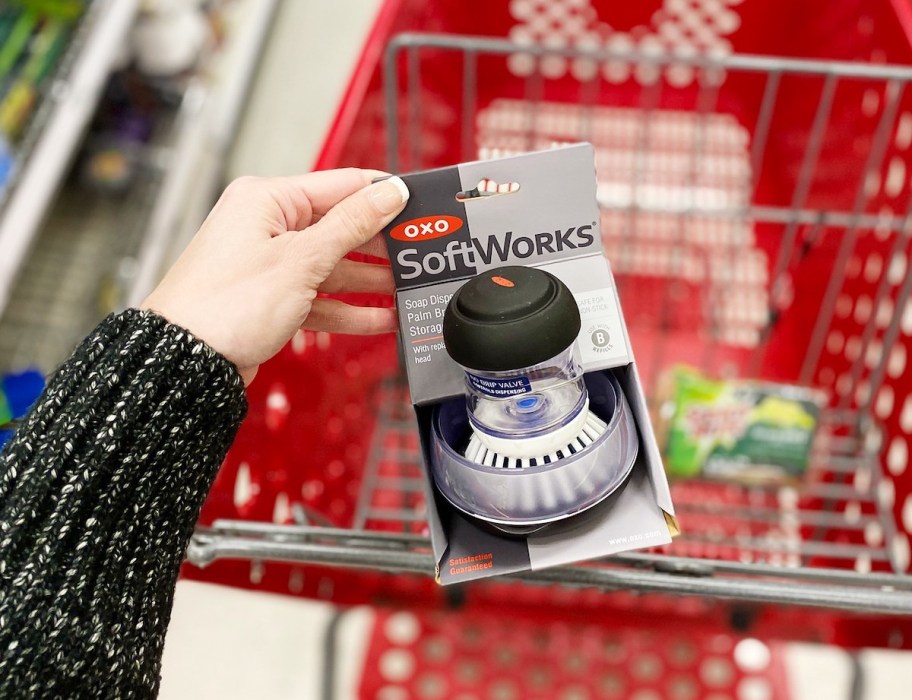 hand holding a oxo brush in package with target cart in background