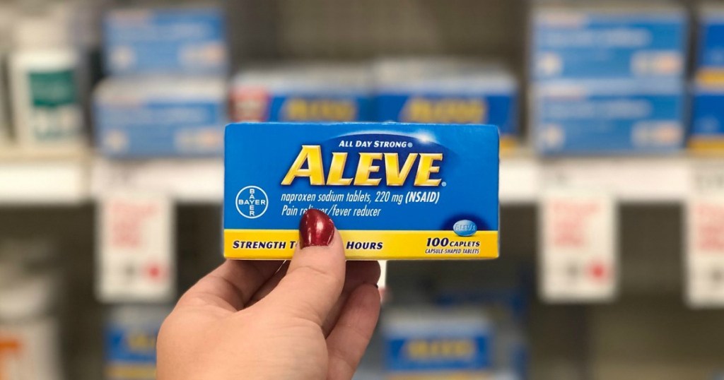 hand holding pain reliever caplets box in a store