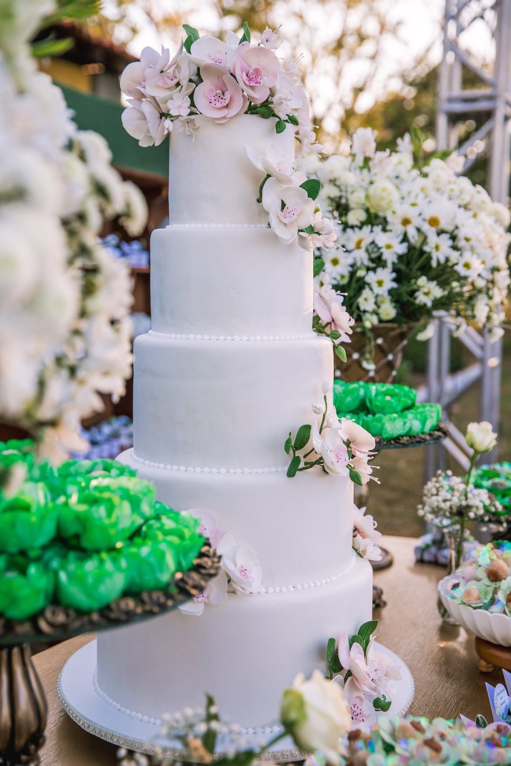 tall white wedding cake with pink flowers on top