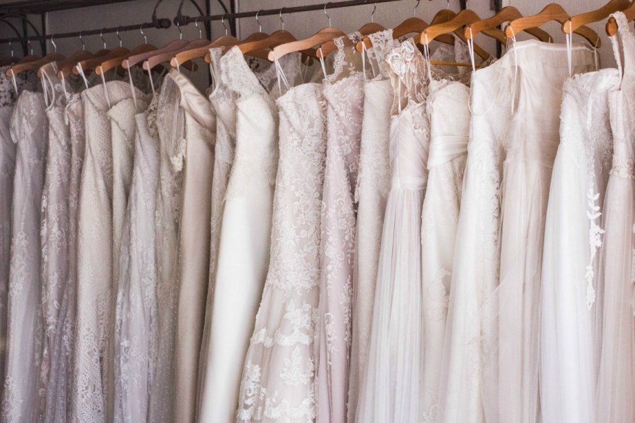 wedding dresses hanging up on wood hangers