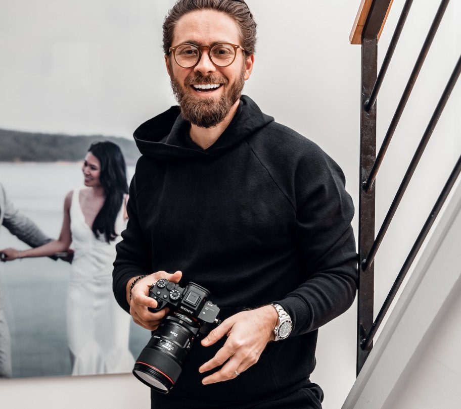 man wearing all black holding canon camera wedding ideas on a budget