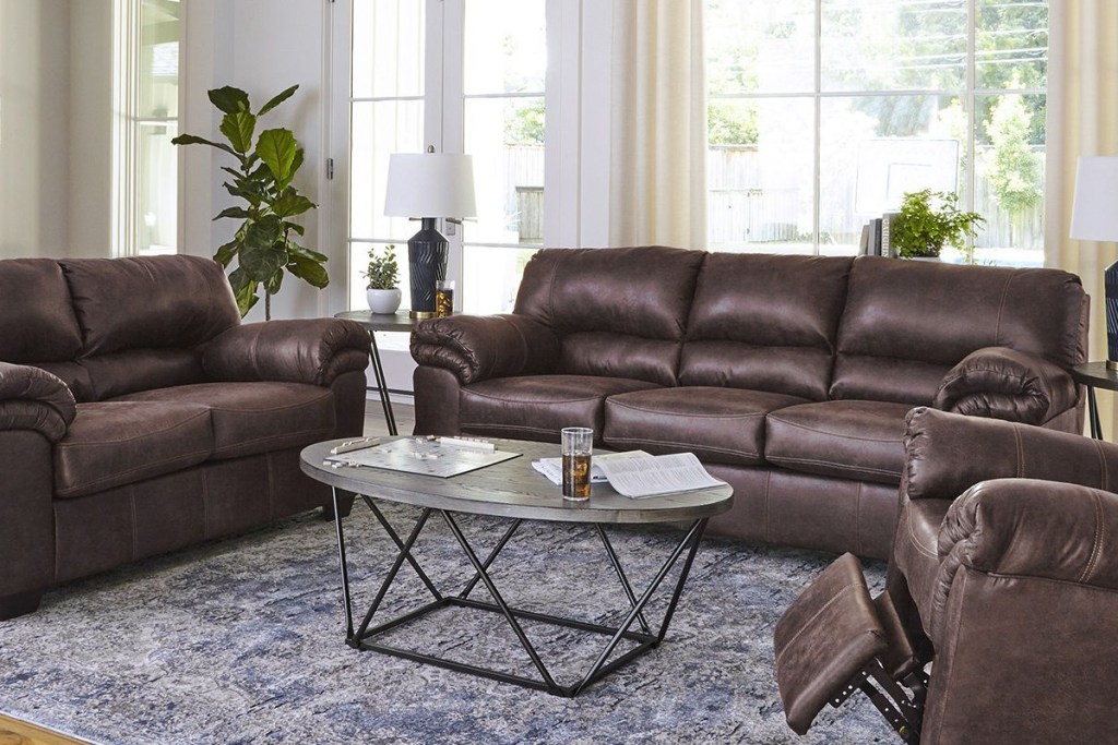 Large brown leather sofa in living room with matching loveseat an recliner chair