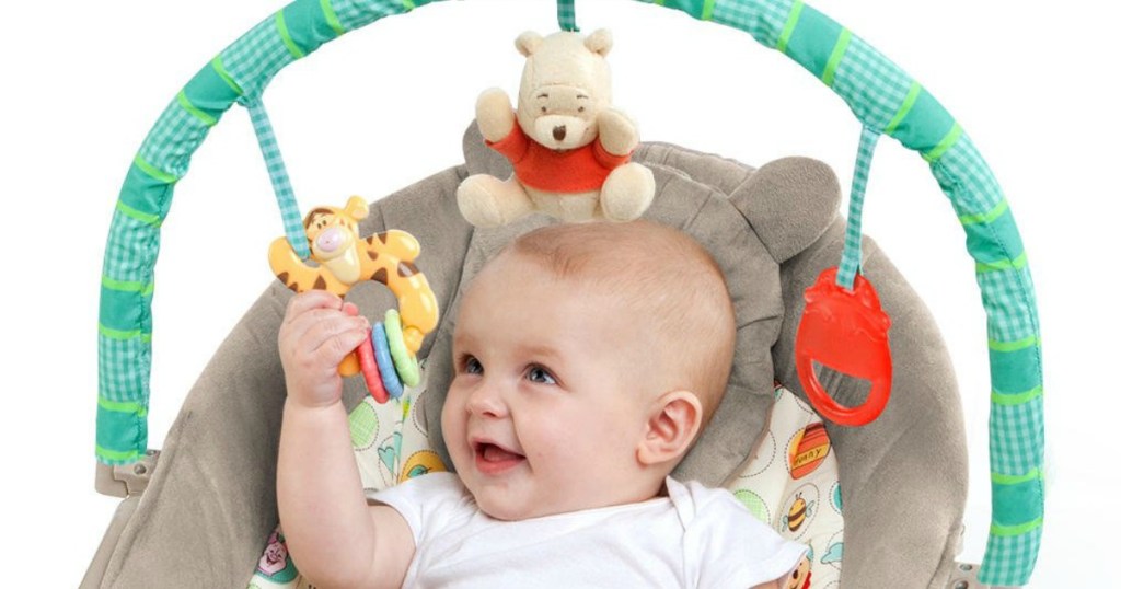 baby in bouncer seat playing with hanging Winnie the Pooh toy