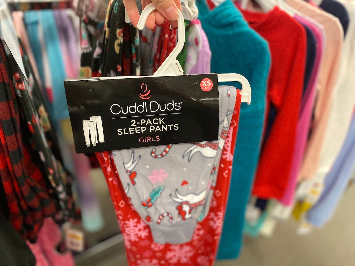 woman hand holding hanger of Girls 4-12 Cuddl Duds 2-Pack Pants in kohls