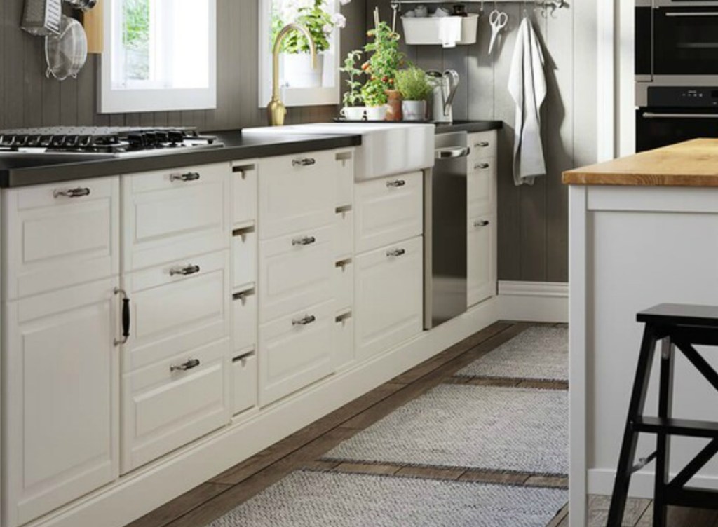 Large kitchen with white cabinets and dark counter top near coordinating island