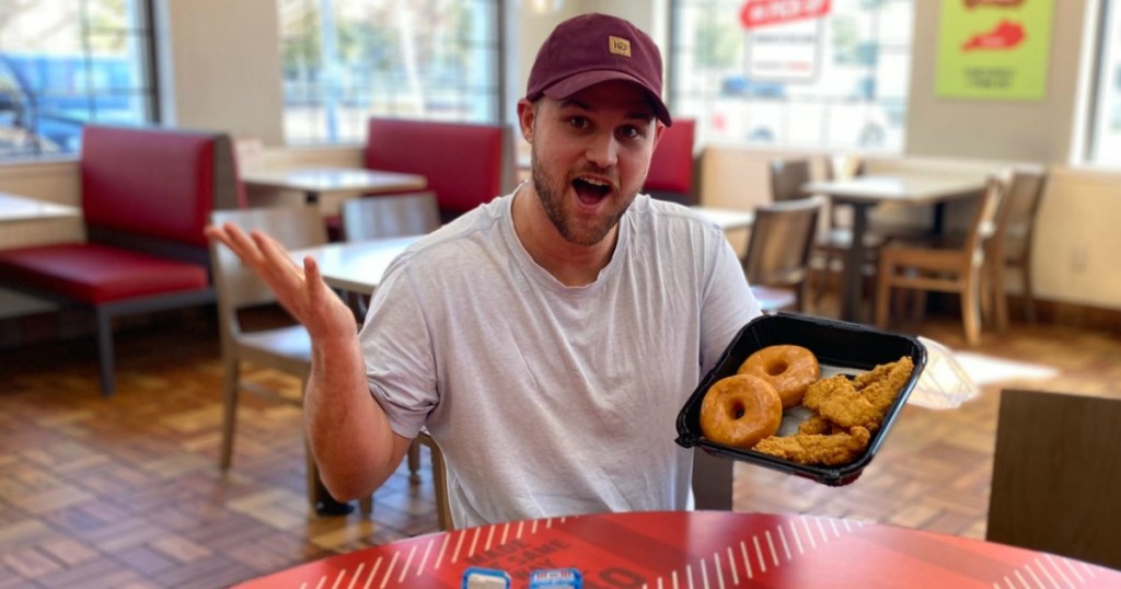 man holding KFC chicken and donuts 