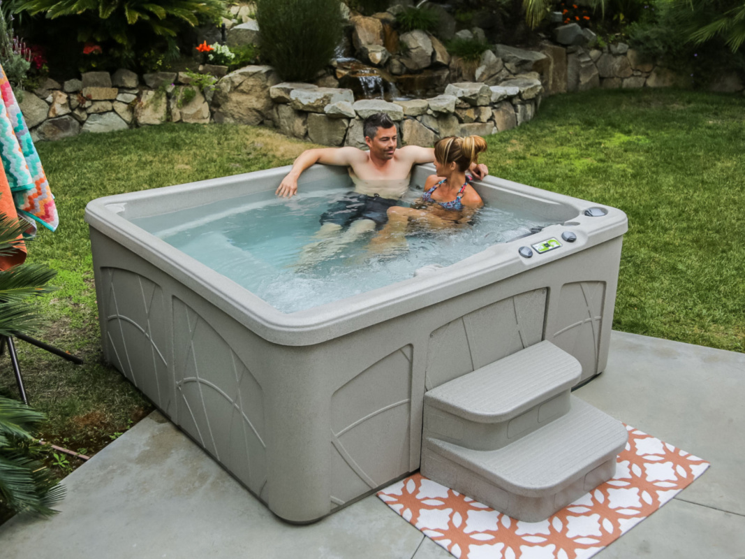 couple relaxing in hot tub in scenic back yard