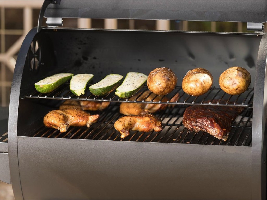 Large grill/smoker with veggies, chicken, and potatoes cooking