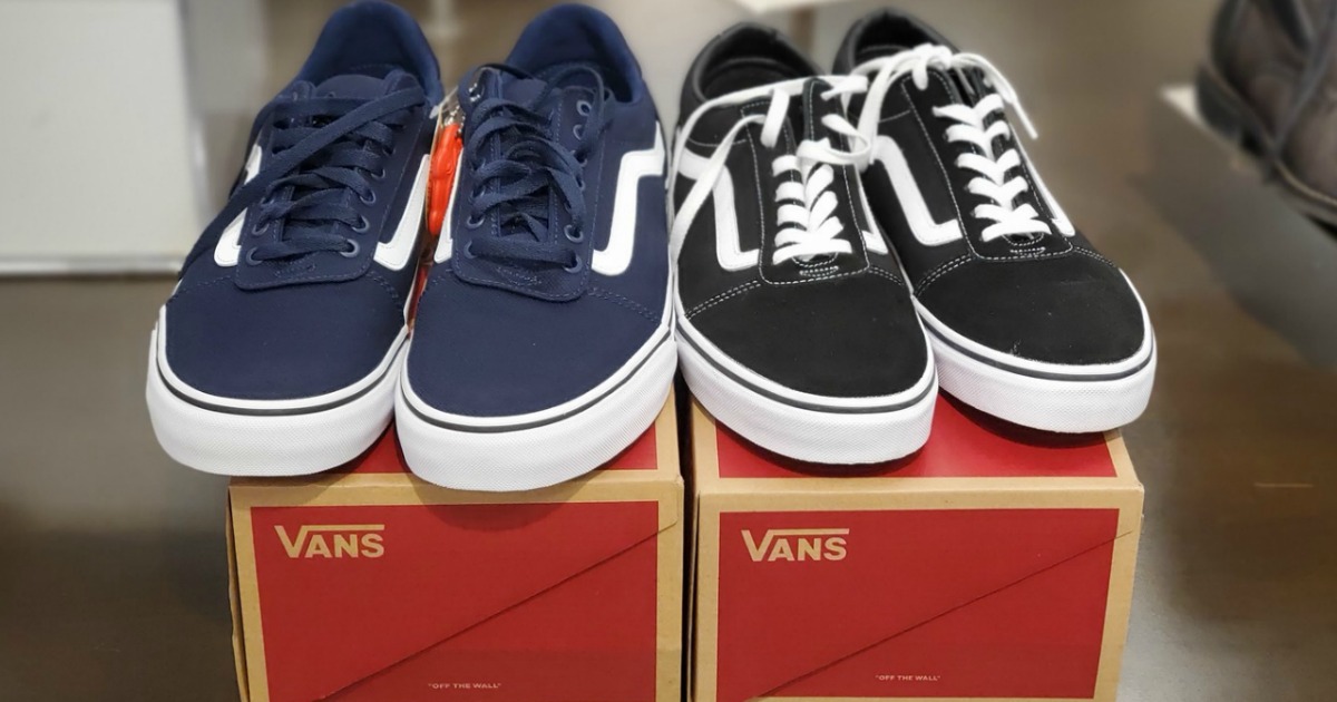 Two pairs of men's suede shoes on top of red shoe boxes in-store