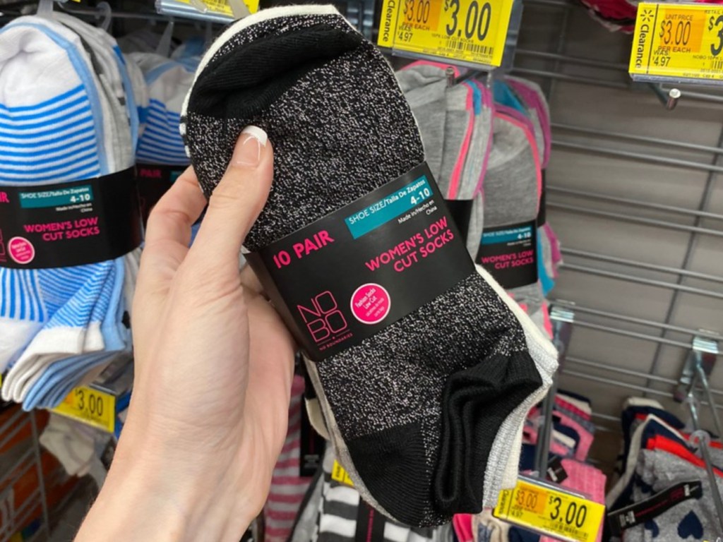 Woman holding pack of socks in store