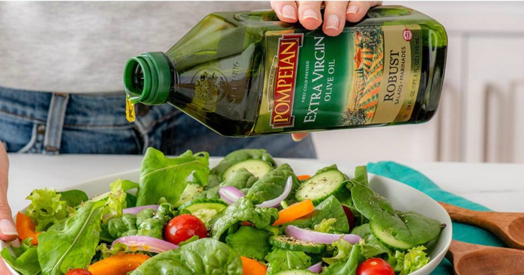 Person pouring Pompeian Olive Oil over salad