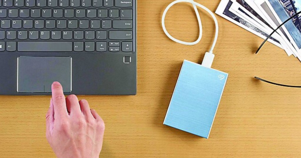 laptop keyboard with a blue hard drive sitting by it