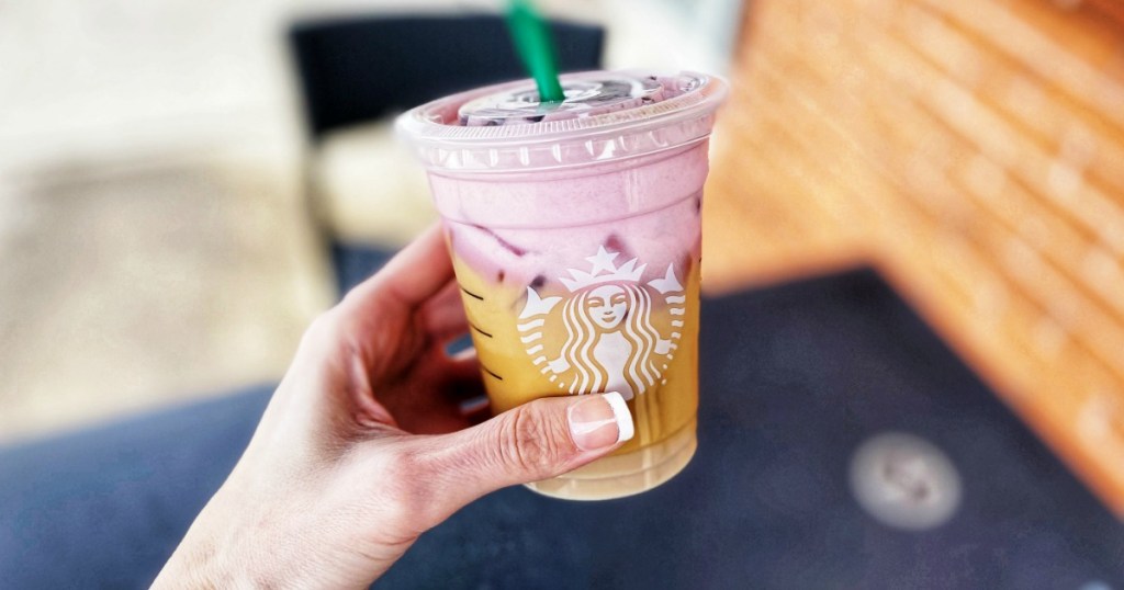 Woman holding Starbucks Secret Chocolate Strawberry Cold Brew drink outside Starbucks cafe