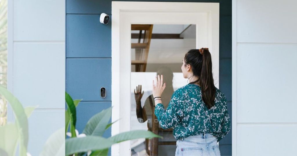 teenage girl waving at surveillance camera outside of home