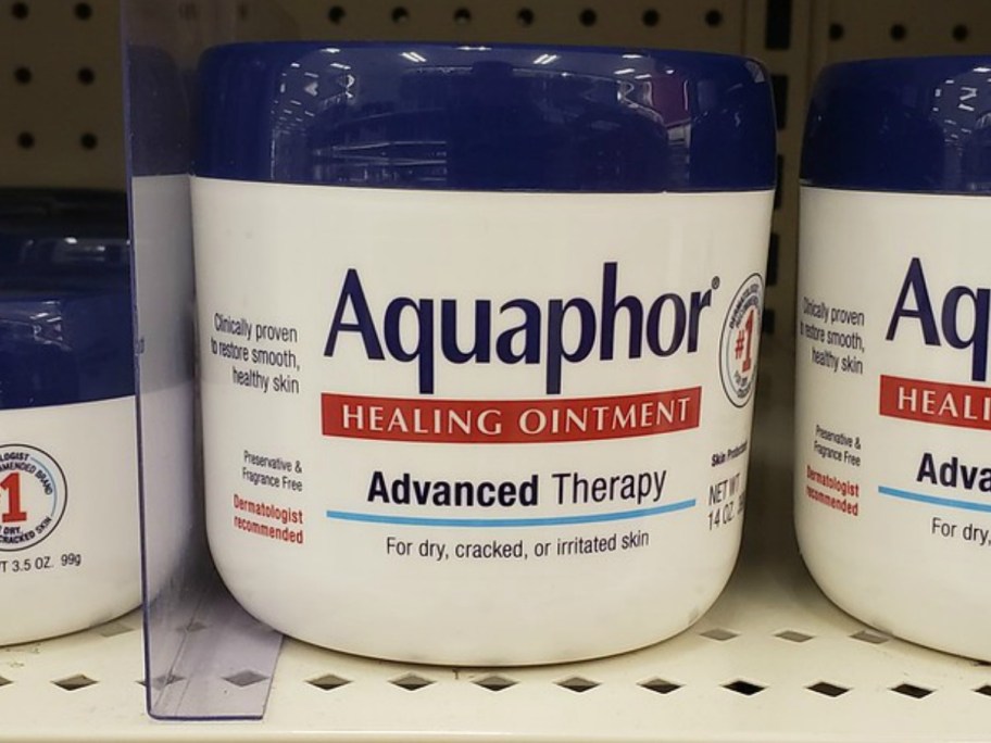 large 14oz white, blue and red jars of Aquaphor Healing Ointment on a store shelf