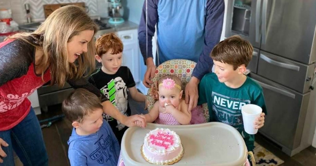 family surrounding baby with cake